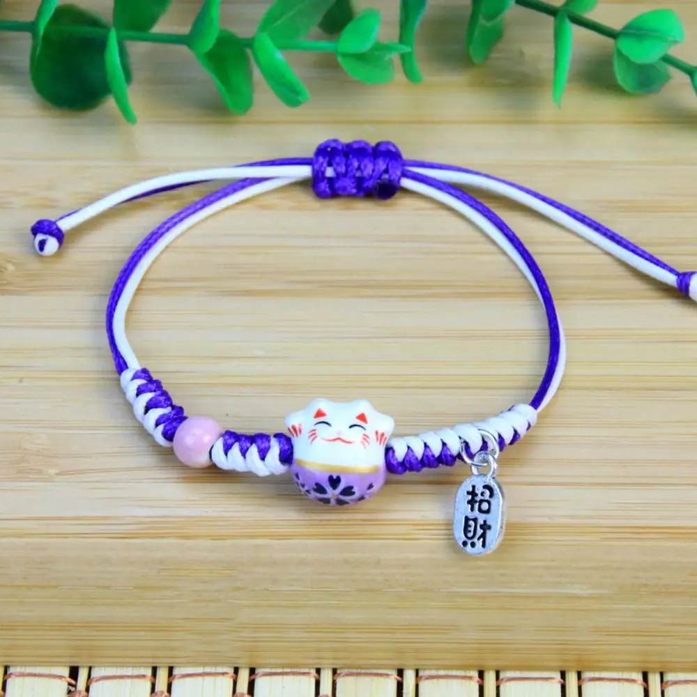 Bransoletka Maneki Neko ceramiczny kot — ręcznie pleciona czerwona lina Rodowany
